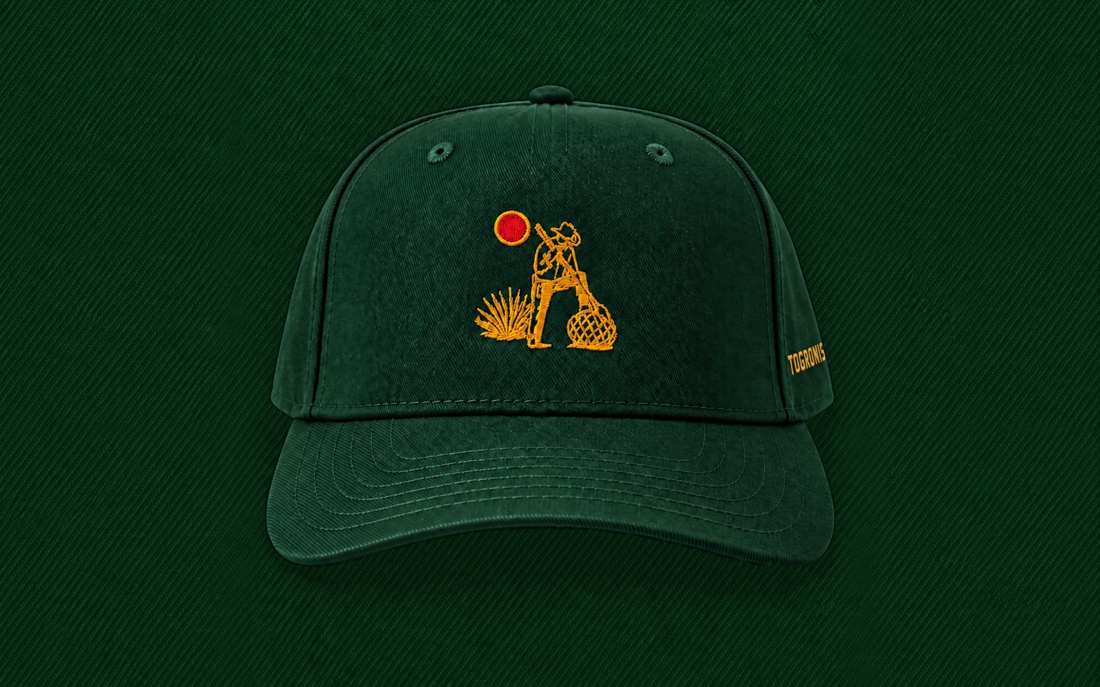 The Jimador Hat from the front: hunter green, with the gold jimador and red sun embroidered on the front and TOGRONIS on the side